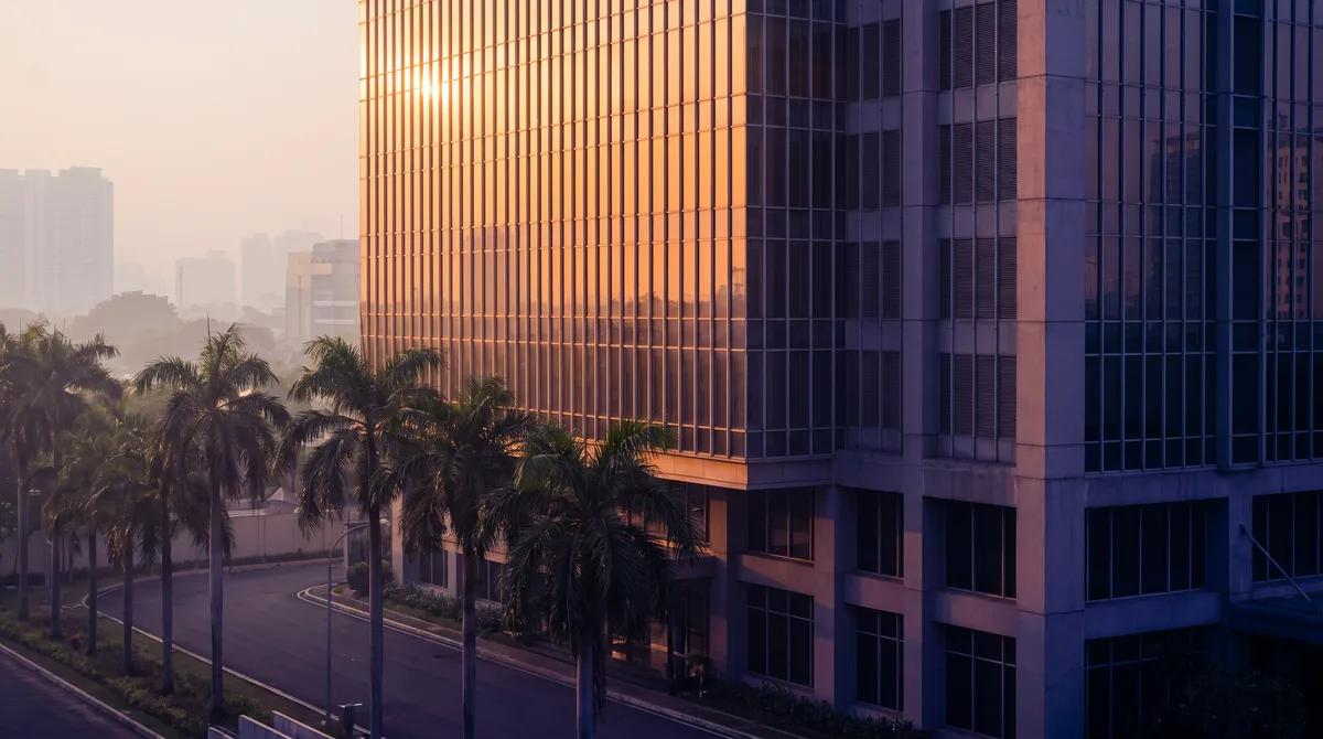 Fasad kaca gedung perkantoran di Jakarta menerima matahari sore dari sisi barat